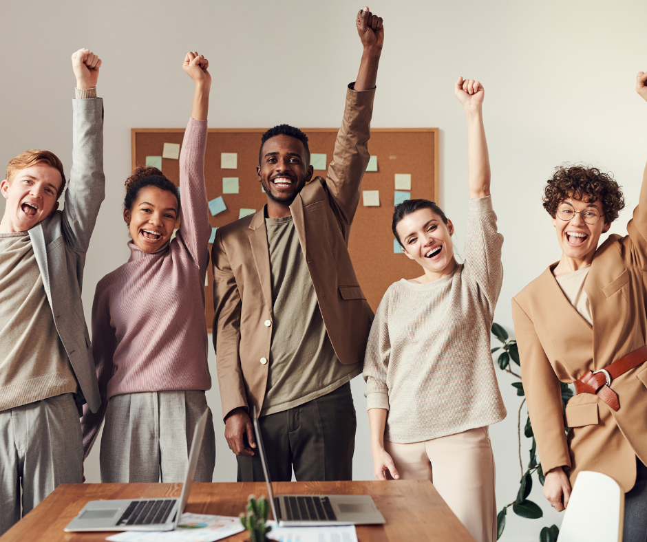 A group of people celebrating success in a positive workplace culture