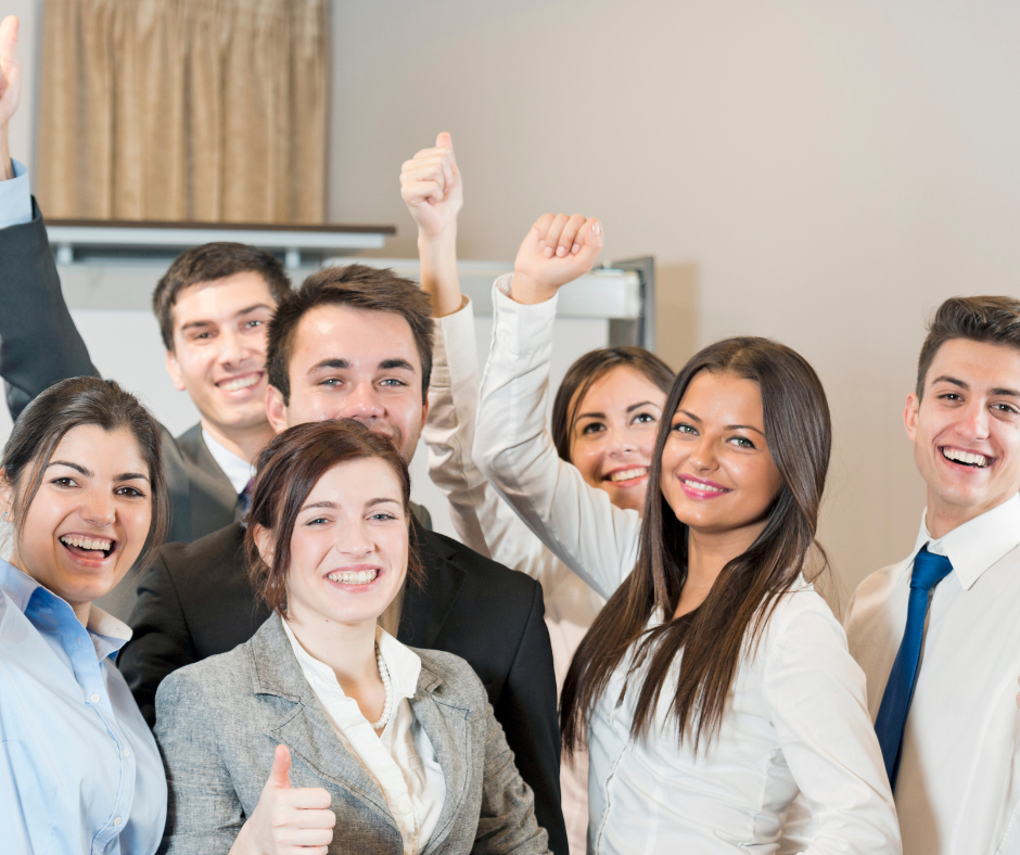 A group of people in a positive work environment, smiling and working together, with a positive attitude
